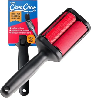 A compact white ChomChom Mini Roller held in one hand to show its small, portable size.
